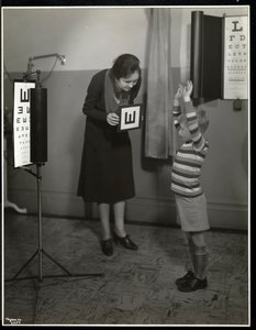 Nurse and a boy patient having an eye test at the New York Association for the Blind, 111 East 59th Street, New York, 1930